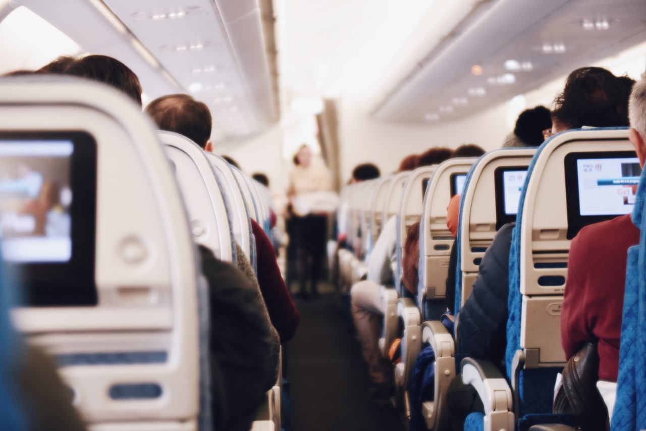 interior of a plane with seated passengers interior of a plane with seated passengers