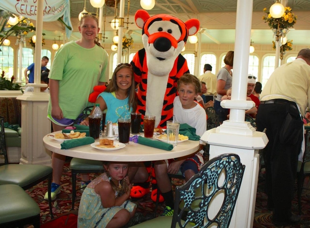 child hiding under a table on vacation as shes scared of tigger