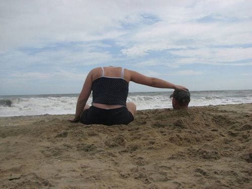 funny vacation photo of woman on a bbeach thats removed her head