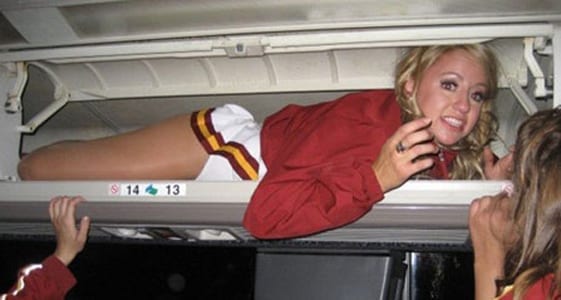 woman squeezed into the overhead luggage on a plane
