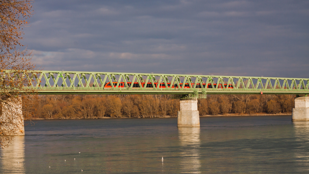 Red train crossing the railway bridge over the river Danube in Budapes